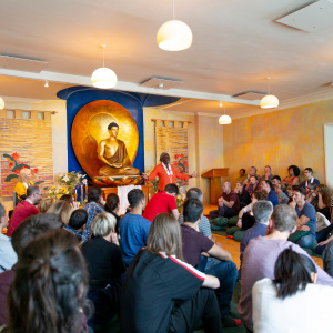 Suryagupta (chair of the London Buddhist Centre) in a packed shrine room during Buddha day. Photo: Sam Roberts / Louise Hall 