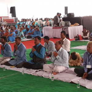 Men are sitting in a row for Mitra ceremony.